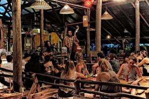 een groep mensen die aan tafel zitten in een restaurant bij The Kasbah Langkawi in Pantai Cenang