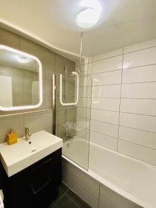 uma casa de banho com um lavatório, um espelho e uma banheira em Traumwohnung Stuttgart em Stuttgart