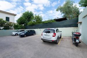 ein weißes Auto parkt auf einem Parkplatz mit einem Roller in der Unterkunft Hotel Gennarino in Livorno