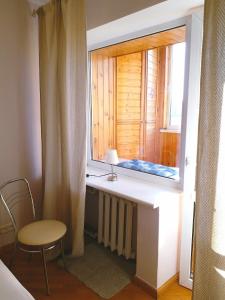 ventana en una habitación con mesa y silla en Отдельная комната с балконом в апартаментах, возле м Печерская en Kiev