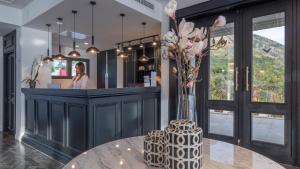 a lobby with a counter with a vase of flowers on a table at Vivid Blue Serenity Resort in Sveti Stefan