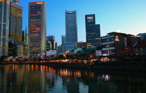 a city skyline with tall buildings next to a river at Heritage Collection on Boat Quay - South Bridge Wing in Singapore