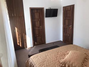 a bedroom with a bed and two wooden doors at Casa MIKHA in Sinaia