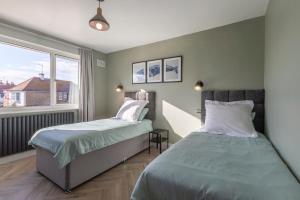 a bedroom with two beds and a window at Palm Bay Beach House in Margate
