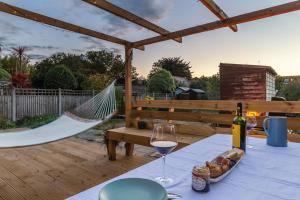 a table with a glass of wine and a hammock at Palm Bay Beach House in Margate