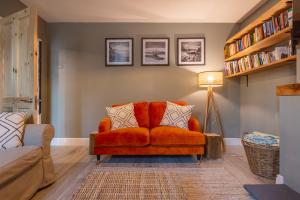 an orange couch in a living room with a lamp at Palm Bay Beach House in Margate