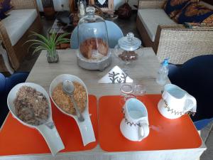 uma mesa com tigelas de comida e colheres em FIGTREE GUESTHOUSE em Maputo