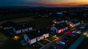 a house with cars parked in a parking lot at night at Słoneczne Wzgórze Zator in Zator