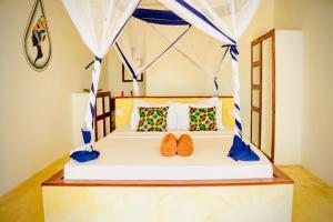 a bedroom with a bed with two shoes on it at Mnana Beach Bungalows in Michamvi