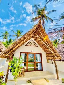 a small house with a thatched roof at Mnana Beach Bungalows in Michamvi