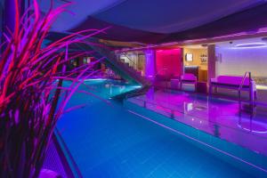 a swimming pool with purple lights in a room at Johan Suites & Spa in Kuressaare