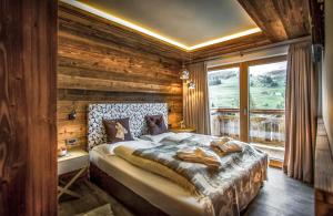 1 dormitorio con 1 cama en una habitación con paredes de madera en Chalet Stefan - Apartments, en La Villa