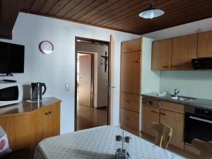 eine Küche mit Holzschränken und einem Tisch darin in der Unterkunft Mascherhof in Obertilliach