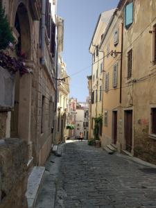 an empty street in an alley between buildings at Apartments E & E Piran in Piran +10 photos