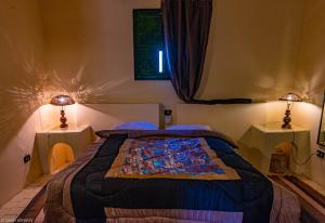 een slaapkamer met een bed met 2 tafels en 2 lampen bij Siwa Shali Resort in Siwa