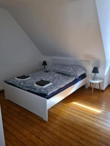 uma cama branca num quarto com piso em madeira em GP Ferienwohnung em Goslar