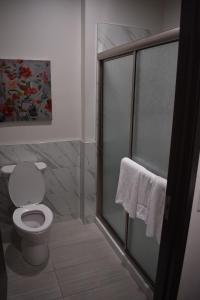 a bathroom with a toilet and a glass shower stall at Grand Villa - Humble in Humble