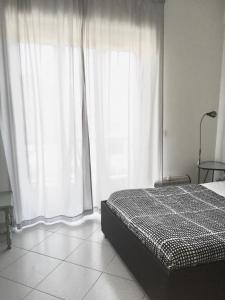 a bedroom with a bed and a large window at A Casa Mia Apartment in Catania