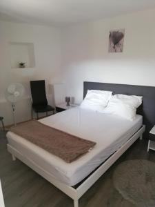 a white bed with a brown blanket on top of it at Ancienne caserne du château in Azille