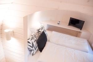 een kleine kamer met een bed en een laptop op een plank bij Freches Wohnen Igluhuts in Lindau