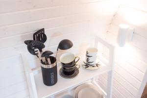 a white shelf with cups and utensils on it at Freches Wohnen Igluhuts in Lindau