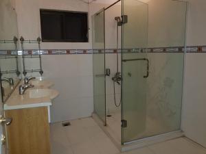 y baño con ducha y lavamanos. en White Lodge Guest House, en Islamabad