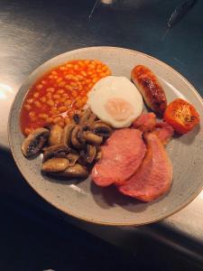 a plate of food with eggs mushrooms beans and meat at Slaters Country Inn in Whitmore