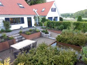 BorupKoppes Mølle B&B - naturnær overnatning的房屋前设有带桌椅的花园