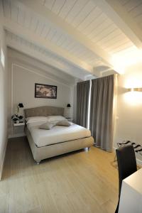 sypialnia z dużym łóżkiem w pokoju ze stołem w obiekcie B&B La Dolce Vita w mieście Fondi