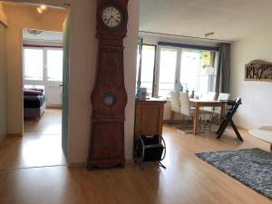 um grande relógio avô de madeira numa sala de estar em Wohnung mit See und Bergsicht im vier Sterne Hotel em Beatenberg