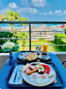 una mesa azul con una bandeja de comida para el desayuno. en Katerina Seaside Studios en Plataniás
