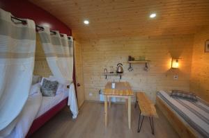 - une chambre avec un lit et une table dans l'établissement Le camp du fauconnier, à La Pommeraie-sur-Sèvre