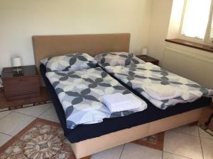 a bed with two pillows on it in a room at RRR Apartmány in Bojnice