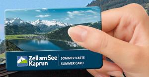 uma mão segurando um cartão com uma foto de um lago em Hotel Garni Landhaus Gitti em Zell am See