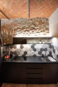 uma cozinha com um balcão preto e um lavatório em Fioraia5 Dimora em Arezzo