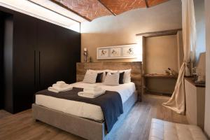 una camera da letto con un grande letto con asciugamani di Fioraia5 Dimora ad Arezzo