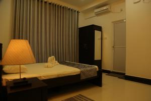 a bedroom with a bed with a lamp and a window at SkyCasa Holiday Apartments in Mount Lavinia