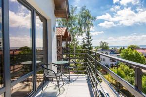 a balcony with chairs and tables on a building at Villa Pacyfic in Krynica Morska