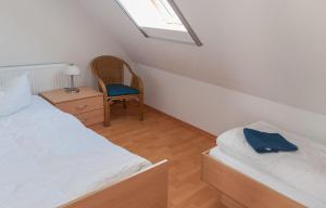 um quarto com 2 camas, uma cadeira e uma janela em Ferienhaus Plau am See direkt am Strand em Plau am See