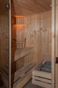 uma sauna de madeira com um balde numa prateleira em Ferienhaus Plau am See direkt am Strand em Plau am See