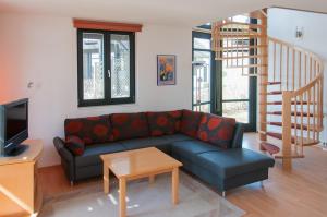 uma sala de estar com um sofá e uma escada em Ferienhaus Plau am See direkt am Strand em Plau am See