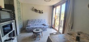 sala de estar con sofá y TV en Studio 4 à 5 personnes Saint Jean Montclar, en Montclar