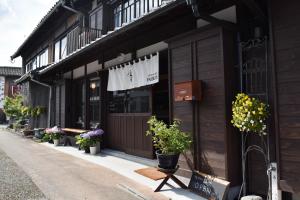 a store with potted plants on the side of a building at Hostel&Cafe Farolito in Ukiha