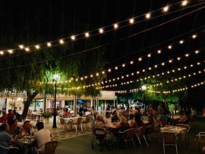 un grupo de personas sentadas en mesas bajo las luces en Hotel Rural Puerto Mágina, en Torres