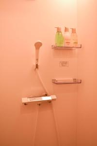 łazienka z telefonem i butelkami na ścianie w obiekcie Hostel&Cafe Farolito w mieście Ukiha