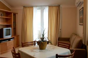 Villa Koala Apartments في زابوريتش: غرفة معيشة مع طاولة عليها نبات