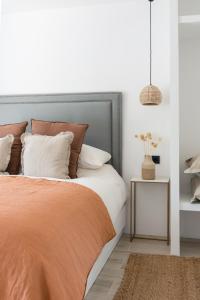 sypialnia z łóżkiem z pomarańczowym kocem w obiekcie The Olive Boutique Suites & Spa w mieście Cala Llonga +37 zdjęć