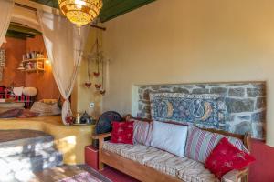 a living room with a couch with red pillows at The Old Pomegranate House in Mirsíni