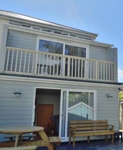a house with a deck and two picnic tables at Gwel Angarder in Perranporth
