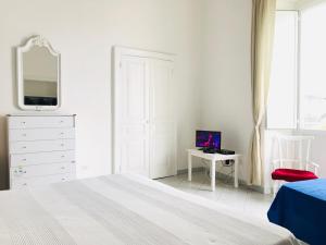 a white bedroom with a bed and a mirror at Casa Tatillo - Immobilevante in Ponza